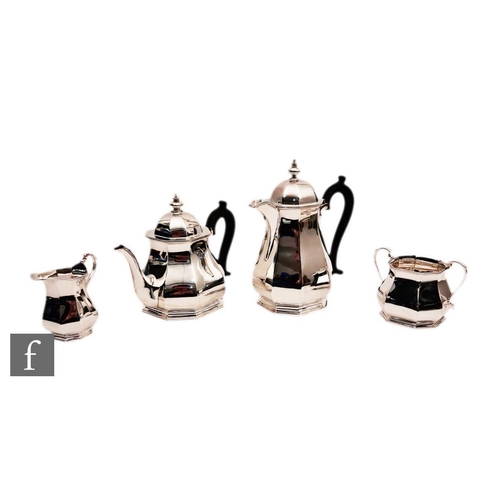 28 - A hallmarked silver four piece tea set of plain paneled baluster form terminating in turned wooden h... 