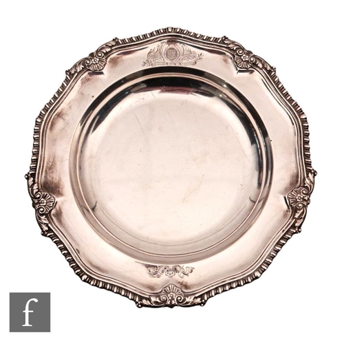 39 - A George IV hallmarked silver shallow plate of plain form with engraved crest within gadroon and she... 