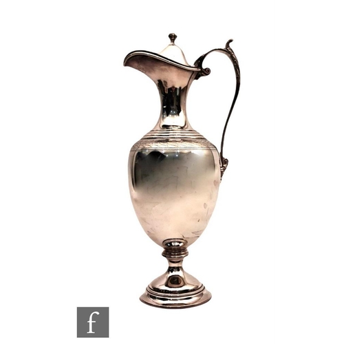 50 - A hallmarked silver claret jug of plain baluster form detailed with an engraved chevron band below h... 