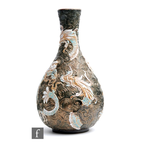 23 - A late 19th Century Doulton Lambeth bottle vase decorated in relief with dragons heightened in blue ... 