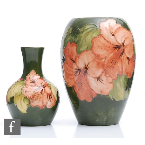 33 - Two Moorcroft vases of varying form decorated in the Hibiscus pattern with coral flowers against a g... 