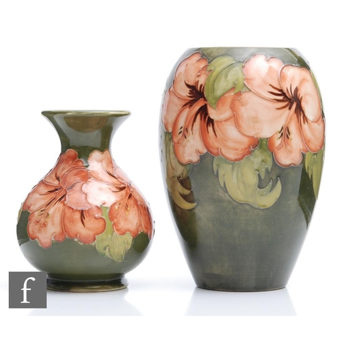 34 - Two Moorcroft vases of varying form decorated in the Hibiscus pattern with coral flowers against a g... 