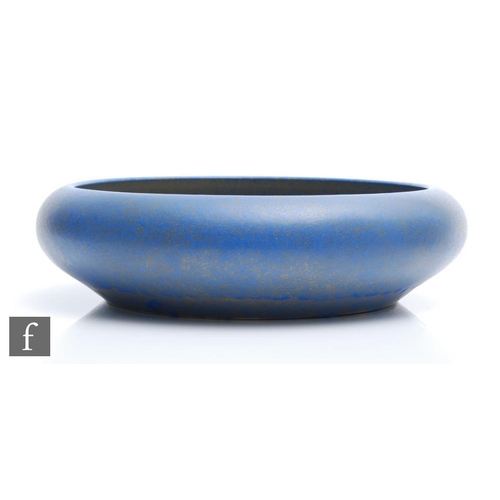 58 - A large Ruskin Pottery float bowl decorated in a mottled and fissured blue over a dark green ground,... 
