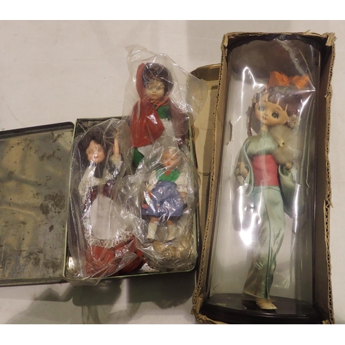 1038 - Tin containing three vintage souvenir dolls and a boxed vintage doll on a stand. Not available for i... 