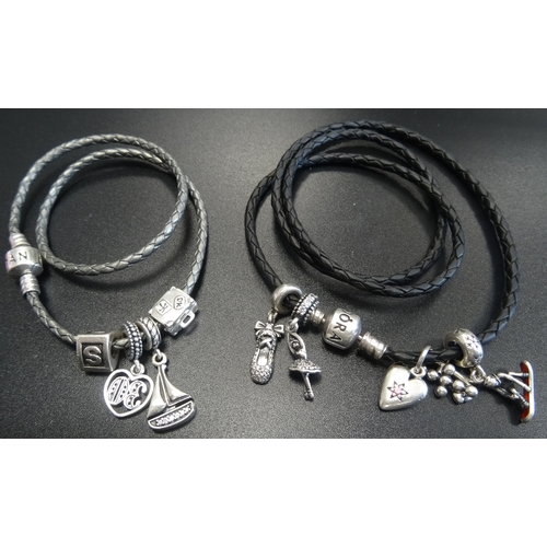 17 - TWO PANDORA CHARM BRACELETS WITH CHARMS
comprising a black woven triple bracelet and a silver/grey w... 