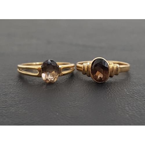39 - TWO OVAL CUT SMOKY TOPAZ SINGLE STONE RINGS
both on nine carat gold shanks, one with decorative spli... 