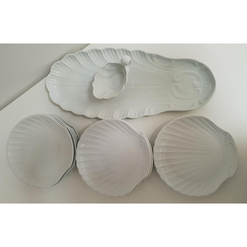 169 - PORCELAIN FISH PLATES
in white and comprising a fish serving plate, shell shaped sauce boat and elev... 