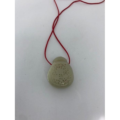 33 - A Reticulated Chinese jade bottle with red cord jade bottle with red cord; 8.66g