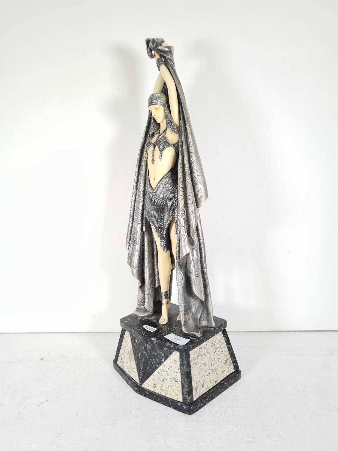 An Art Deco style resin female figurine with pewter finish cloak on