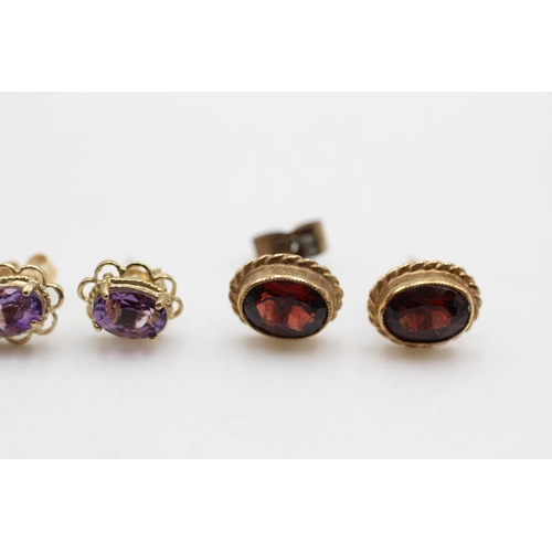 50 - Two 9ct gold paired gemstone solitaire stud earrings, one garnet and one amethyst - approx. gross we... 