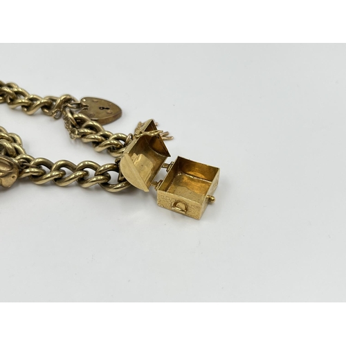 1141 - A 9ct gold charm bracelet with hallmarked Birmingham 9ct heart shaped clasp and five yellow metal ch... 