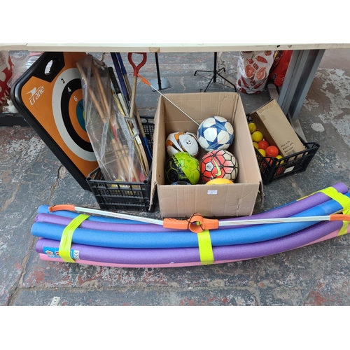 Three boxes containing various sports equipment to include footballs