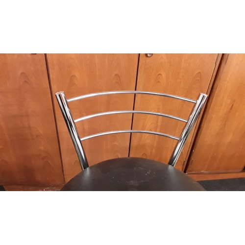 1467 - A pair of chrome bar stools with backs and black leather seat pads.