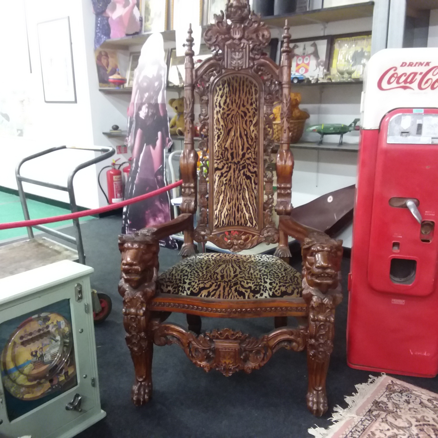 A hand carved tribal Throne chair upholstered in a leopard print seat