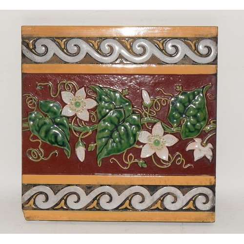 283 - Minton Hollins moulded majolica dado tile depicting white clematis on a burgundy ground with white &... 