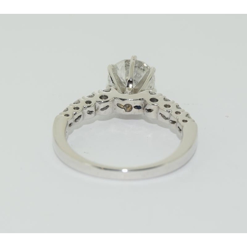 1086 - An 18ct white gold ring, the central stone of 1.5ct with diamond shoulders. Size L