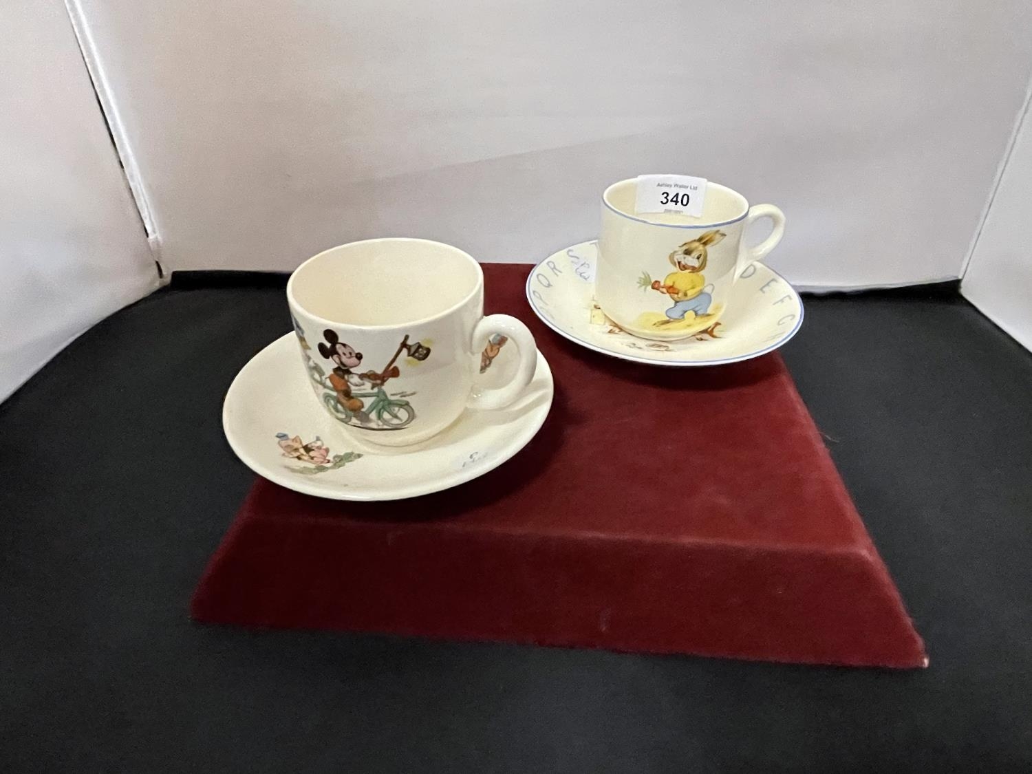 A BESWICK WALT DISNEY CUP AND SAUCER AND AN ELIJAH COTTON LTD LORD ...