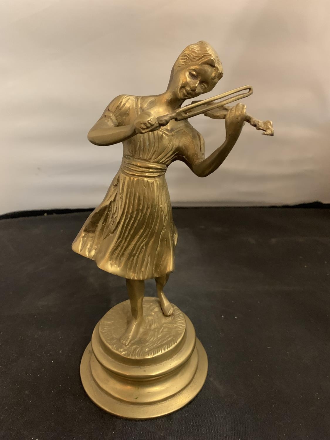 A BRASS FIGURINE IN THE FORM OF A GIRL PLAYING THE VIOLIN (H24CM)