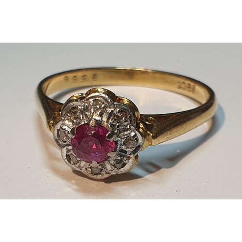 18 - A ruby and vari-cut diamond cluster ring. Stamped 18ct.Ring size P. 3.2gms.