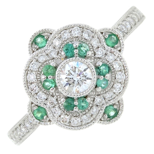 21 - An 18ct gold diamond and emerald dress ring. Total emerald weight 0.11ct. Total diamond weight 0.40c... 