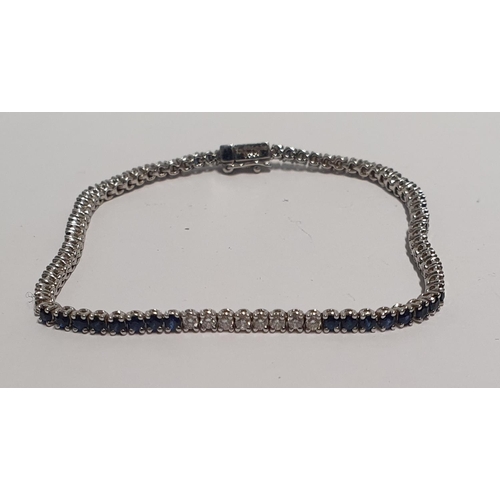 32 - A fabulous Platinum, Diamond and Sapphire Tennis Bracelet, with forty Brilliant cut Diamonds and for... 