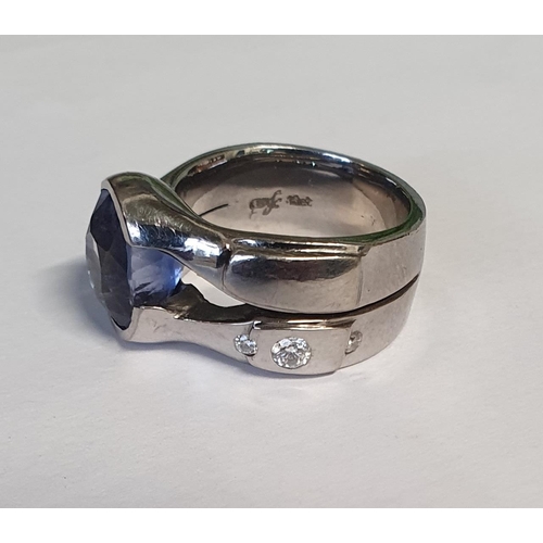 47 - An 18ct White Gold Ring. Handwrought with three diamonds, brilliant cut, round and one sapphire, ova... 