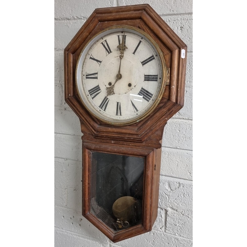 42 - A 19th Century Oak Wall Clock with pendulum and key.