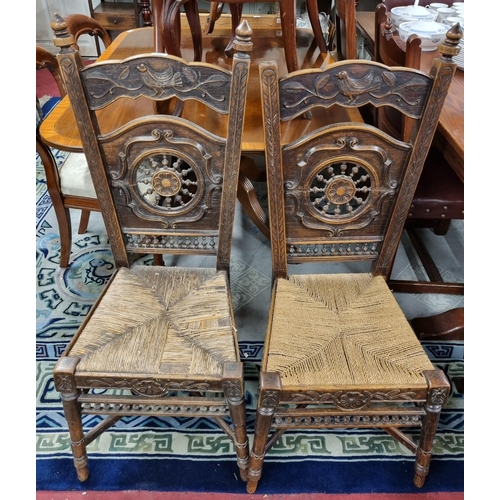 41 - A pair of late 19th Century Oak Hall Chairs, with circular maritime carved backs with rush seats and... 