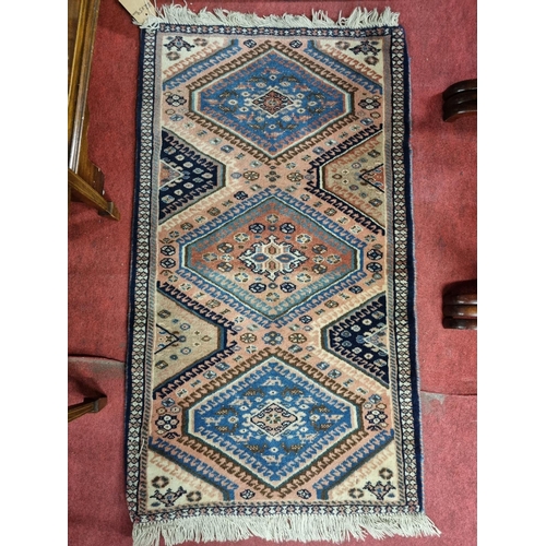 99 - A good Persian Rug with blue and pink ground and zig zag decoration. 102 x 59 cms approx.