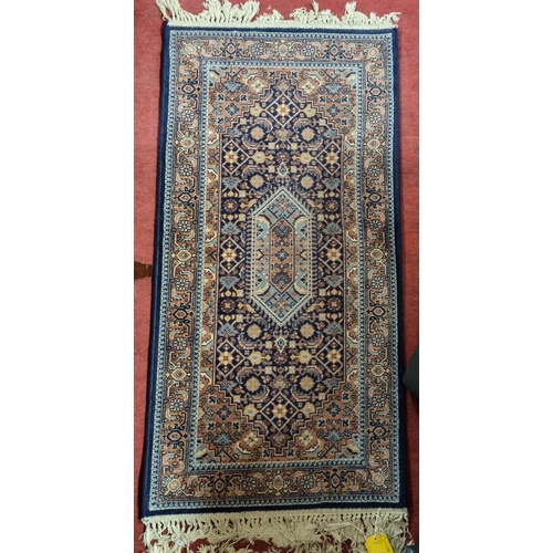 98 - A blue ground Rug with all over decoration. 135 x 68 cms approx.