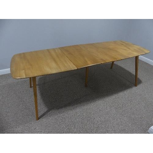 4 - A mid 20thC Ercol light elm plank top extending Dining Table, of rounded rectangular form, with spla... 