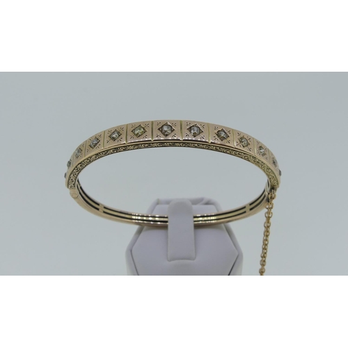 180 - A late Victorian gold Hinged Bangle, the front gypsy set with thirteen old cut stones, all in an eng... 