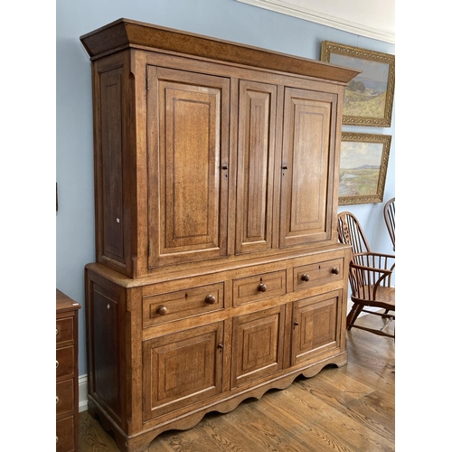 563 - A George III oak Housekeepers Cupboard, the two fielded panel doors with mahogany banding opening to... 