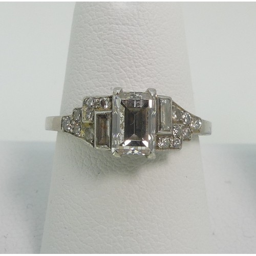 162 - An Art Deco style diamond Dress Ring, the front vertically off set with three baguette diamonds, the... 