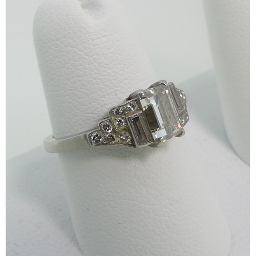 162 - An Art Deco style diamond Dress Ring, the front vertically off set with three baguette diamonds, the... 