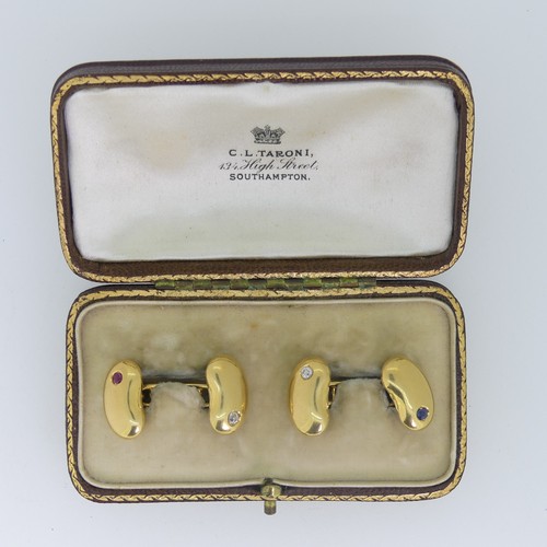 A pair of 18ct gold 'bean' Cufflinks, one with ruby and diamond points, the other with sapphire and diamond points, approx total weight 8.7g, in fitted presentation case from 'C.L.Taroni Southampton'.