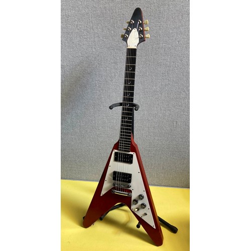 A Gibson Flying V electric guitar with worn cherry body, white three