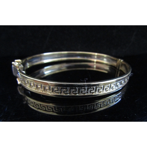 5012 - A gold bangle with greek key design, stamped 375, 15.2g