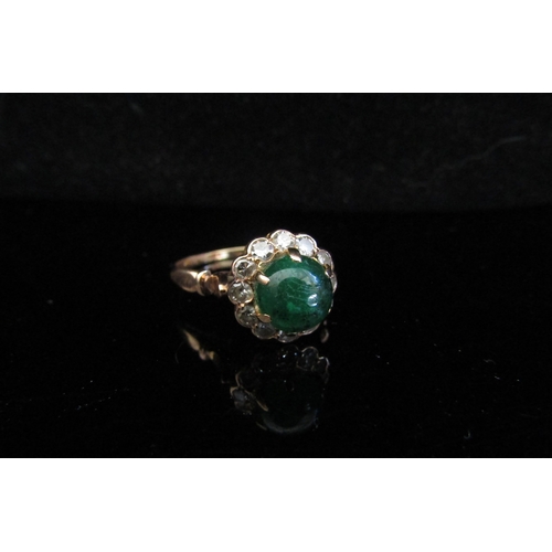 5028 - A gold ring with central emerald cabochon and diamonds, unmarked. Size Q, 3.2g