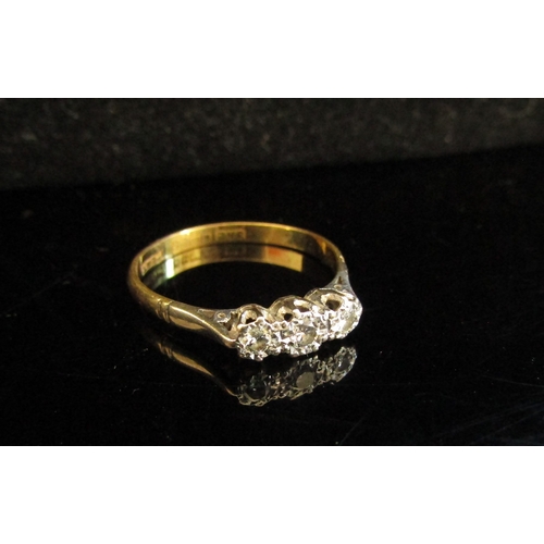 5042 - An 18ct gold platinum set three stone diamond ring in illusion setting. Size R, 2.3g