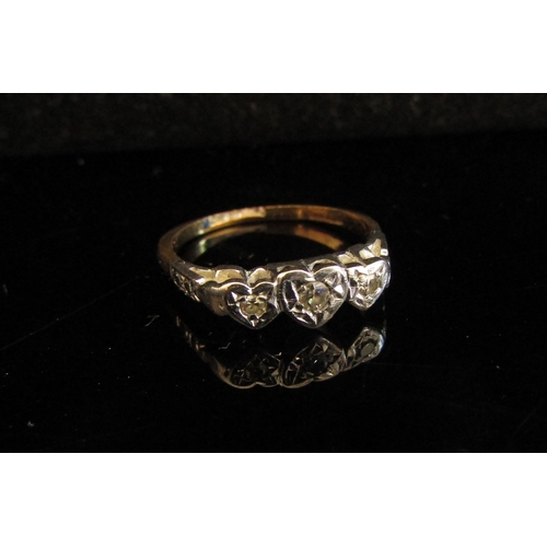 5044 - A gold platinum set three stone diamond ring in heart shaped illusion setting, marks rubbed. Size L,... 