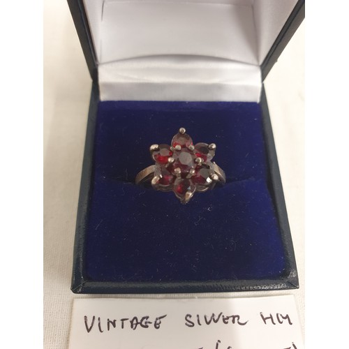 18 - Vintage Silver Hallmarked ring (CWC), Set to 6 point flower shape of red garnet and larger central s... 