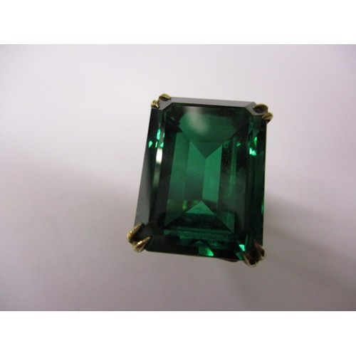 6 - A 9ct yellow gold ring set with a large green synthetic stone. Approximate weight 9.3g
