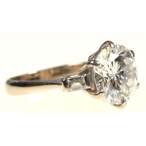11 - A DIAMOND  RING   the round brilliant cut diamond of approx 3.2cts flanked by a baguette diamond to ... 