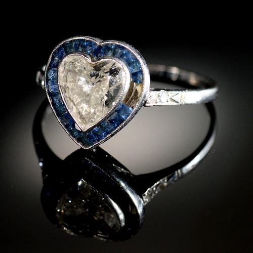 6 - A HEART SHAPED DIAMOND AND SAPPHIRE CLUSTER RING with surround of calibre cut sapphires and diamond ... 