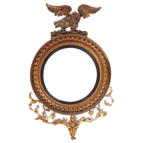 1024 - A George IV giltwood and composition eagle mirror, the convex plate in reeded circular ebonised slip... 