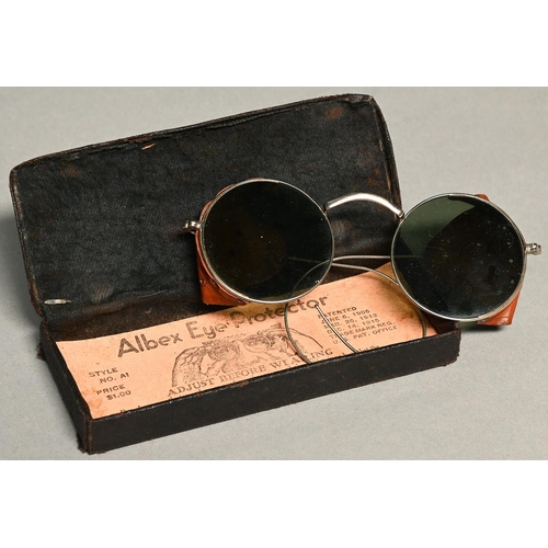 1120 - An American silvered metal, tinted glass and pierced tan leather spectacle Albex eye protector, ... 