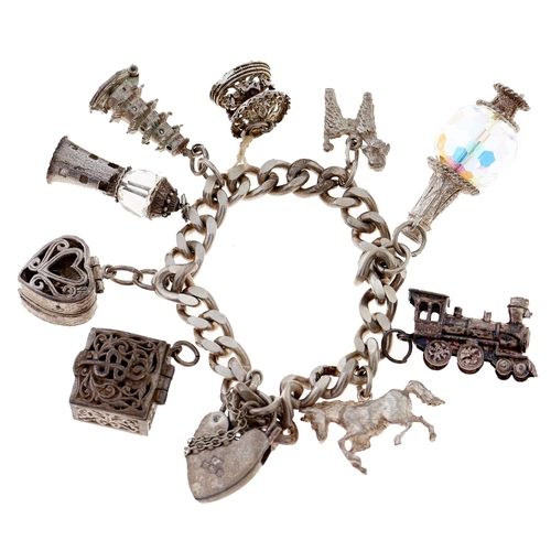 49 - A silver charm bracelet, of flat curb links with padlock and several loose silver charms, to include... 