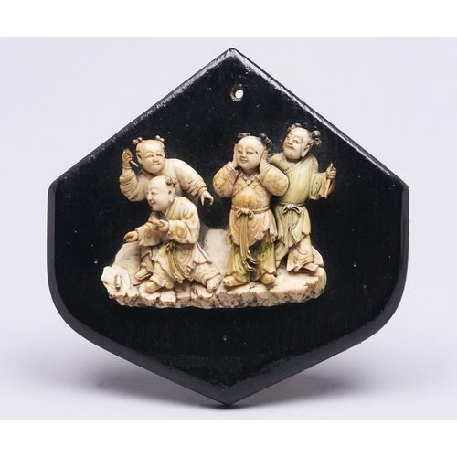 511 - A Japanese ivory carving of four boys, Meiji period, 85mm h, on later affixed black painted wood boa... 