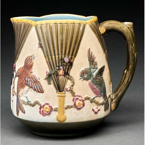 22 - A Wedgwood majolica jug, c1875, moulded with birds on prunus between Japanese fans, the interior tur... 